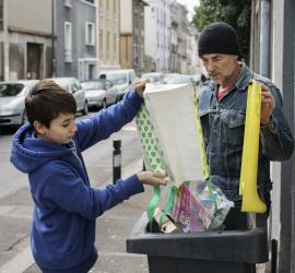 Geste de tri des déchets dans la poubelle jaune